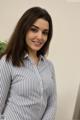 A woman in a blue and white striped shirt posing for a picture.