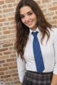 A young woman in a school uniform posing for a picture.