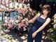 A woman standing in front of a flowering tree.