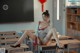 A woman sitting on top of a desk in a classroom.