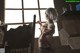 A woman in lingerie standing in front of a window.